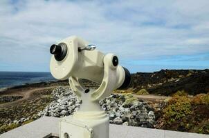 uma telescópio em uma Rocha negligenciar a oceano foto
