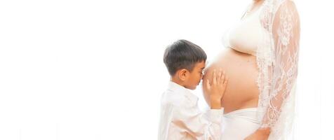 jovem Garoto é se beijando a grávida mulher isolado em branco fundo foto