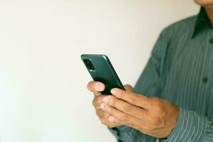 fechar-se tiro do masculino mão usando Smartphone em branco fundo. foto