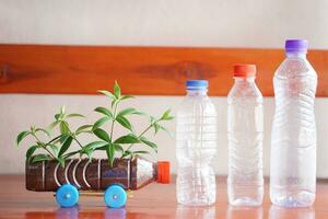 faça você mesmo carro que crescer plantas, fez a partir de plástico garrafa e cápsulas. conceito, plantinha a partir de reciclar trabalhos manuais. reduzir, reuso e reciclar plástico lixo foto