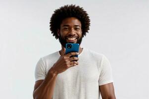 Preto e branco estúdio retrato do homem com afro segurando telefone dentro frente do face, ai gerado foto