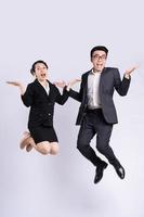 empresário e mulher de negócios pulando sobre fundo branco foto