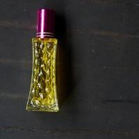 perfume com líquido amarelo em fundo preto