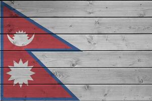 Nepal bandeira retratado dentro brilhante pintura cores em velho de madeira muro. texturizado bandeira em rude fundo foto