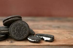 muitos Oreo sanduíche creme biscoitos em de madeira fundo foto