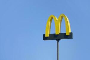 mcdonalds amarelo grande logotipo em azul céu fundo foto