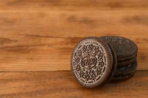 muitos Oreo sanduíche creme biscoitos em de madeira fundo foto