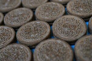 muitos Oreo sanduíche creme biscoitos fechar acima em azul fundo foto