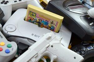 pilha do velho 8 bits vídeo jogos consoles e muitos jogos acessórios gostar uma joysticks e cartuchos foto