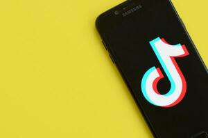 tiktok logotipo em samsung Smartphone tela em amarelo fundo. tiktok é uma popular compartilhamento de vídeo social trabalho em rede serviço possuído de bytedance foto