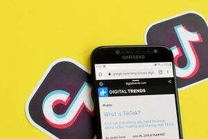 tema sobre tiktok em digitaltrends.com em samsung Smartphone tela em amarelo fundo. tiktok é uma popular compartilhamento de vídeo social trabalho em rede serviço possuído de bytedance foto