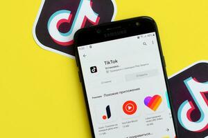 tiktok inscrição dentro playmarket em samsung Smartphone tela em amarelo fundo. tiktok é uma popular compartilhamento de vídeo social trabalho em rede serviço possuído de bytedance foto