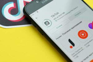 tiktok inscrição dentro playmarket em samsung Smartphone tela em amarelo fundo. tiktok é uma popular compartilhamento de vídeo social trabalho em rede serviço possuído de bytedance foto