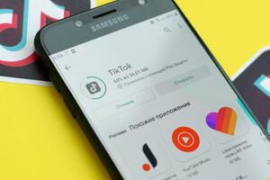 tiktok inscrição dentro playmarket em samsung Smartphone tela em amarelo fundo. tiktok é uma popular compartilhamento de vídeo social trabalho em rede serviço possuído de bytedance foto