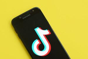 tiktok logotipo em samsung Smartphone tela em amarelo fundo. tiktok é uma popular compartilhamento de vídeo social trabalho em rede serviço possuído de bytedance foto