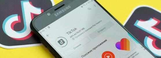 tiktok inscrição dentro playmarket em samsung Smartphone tela em amarelo fundo. tiktok é uma popular compartilhamento de vídeo social trabalho em rede serviço possuído de bytedance foto