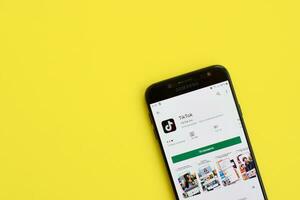 tiktok inscrição dentro playmarket em samsung Smartphone tela em amarelo fundo. tiktok é uma popular compartilhamento de vídeo social trabalho em rede serviço possuído de bytedance foto