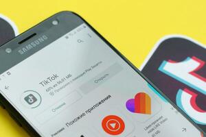 tiktok inscrição dentro playmarket em samsung Smartphone tela em amarelo fundo. tiktok é uma popular compartilhamento de vídeo social trabalho em rede serviço possuído de bytedance foto