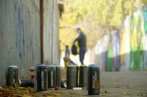 Carcóvia, Ucrânia - Outubro 19, 2019 usava spray latas para grafite pintura de muitos pintura marcas ao ar livre dentro outono folhas e artista dentro pintura processo foto