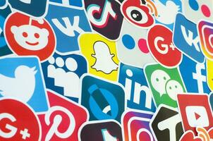 muitos papel ícones com logotipo do a maioria popular social redes e Smartphone apps para bate-papo e conversas conectados foto