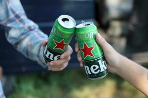 Carcóvia, Ucrânia - Julho 31, 2021 verde lata latas do heineken pálido lager Cerveja dentro homens mãos foto