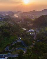 pássaro olho Visão do uma tirar o fôlego paisagem urbana às pôr do sol, pássaro olho Visão do uma cidade aninhado dentro natureza, com pôr do sol matizes. foto