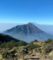 tranquilo montanha pico cercado de vulcânico panorama tranquilo natureza cena com estratovulcão, Claro céu, e montanha pico. foto