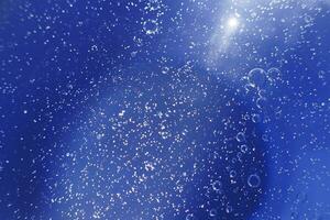 bolhas de óleo fecham. círculos de macro de água. fundo azul claro abstrato foto