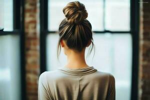 uma lindo noiva com uma pão penteados para grandes cabelo Veja a partir de voltar. uma fêmea Penteado traseiro Visão conceito de ai gerado foto