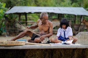 homem idoso e artesanato de bambu com a aluna foto