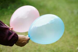 fechar acima mãos aguarde balões dentro a parque. conceito, preparar balão para jogando jogos Como uma brinquedo, decorar festa ou celebração. lazer ou lazer atividade. Diversão e feliz tempo. foto