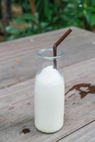 garrafa de milk-shake de baunilha em madeira foto