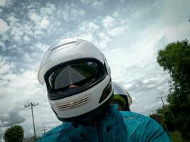 homem vestindo branco capacete dirigindo uma motocicleta foto