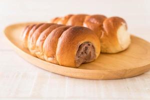 pãozinho com creme no prato de madeira foto