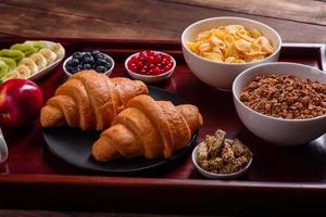 delicioso café da manhã com croissants frescos e frutas vermelhas maduras foto