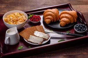 delicioso café da manhã com croissants frescos e frutas vermelhas maduras foto