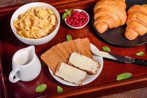 delicioso café da manhã com croissants frescos e frutas vermelhas maduras foto