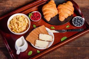 delicioso café da manhã com croissants frescos e frutas vermelhas maduras foto