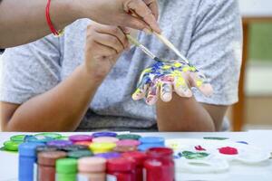 Adolescência Garoto apreciar pintura aguarela em dele mão às escola arte clube, conceito do escola eletiva Atividades, arte talento habilidade foto