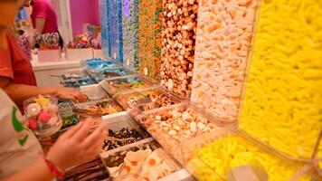 plástico frascos preenchidas com colorida doce dentro fazer compras. foto