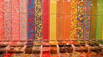 plástico frascos preenchidas com colorida doce dentro fazer compras. foto