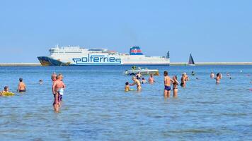 swinoujscie, Polônia. 15 agosto 2023. pessoas dentro a água em a de praia durante feriado estação dentro sobre báltico mar. foto
