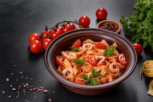 macarrão fettuccine com camarão, tomate cereja, molho, especiarias e ervas foto