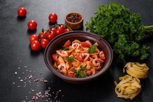 macarrão fettuccine com camarão, tomate cereja, molho, especiarias e ervas foto