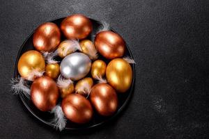 ovos de páscoa ouro e bronze e bolo de páscoa em fundo escuro foto