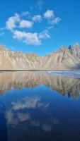 Vestrahorn rochoso montanhas dentro Islândia, Stokksnes de praia formando lindo nórdico natural cenário. fantástico panorama com famoso Preto areia praia, islandês natureza em oceano litoral. foto