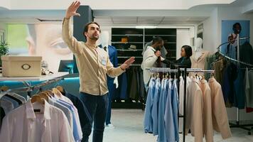 loja Gerente trabalhando com aumentado realidade holograma dentro compras Centro, olhando às moderno na moda roupas em cabides. varejo trabalhador usando artificial inteligência dentro butique, pequeno negócios. foto