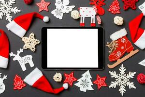 vista superior do tablet digital. decorações de ano novo em fundo preto. feliz natal conceito foto