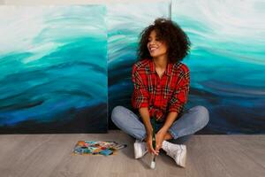 retrato do uma jovem africano aluna sentado com surpreendente abstrato mar acrílico mão desenhado obra de arte às a estúdio. foto