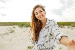 uma mulher dentro a laranja vestir e chapéu em a de praia foto